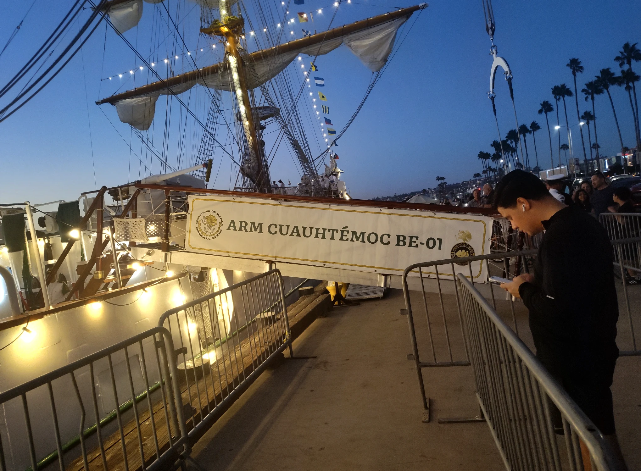 ARM Cuauhtémoc BE-01 docked at night with visitors nearby, illustrating the idea of visible presence and message reach.