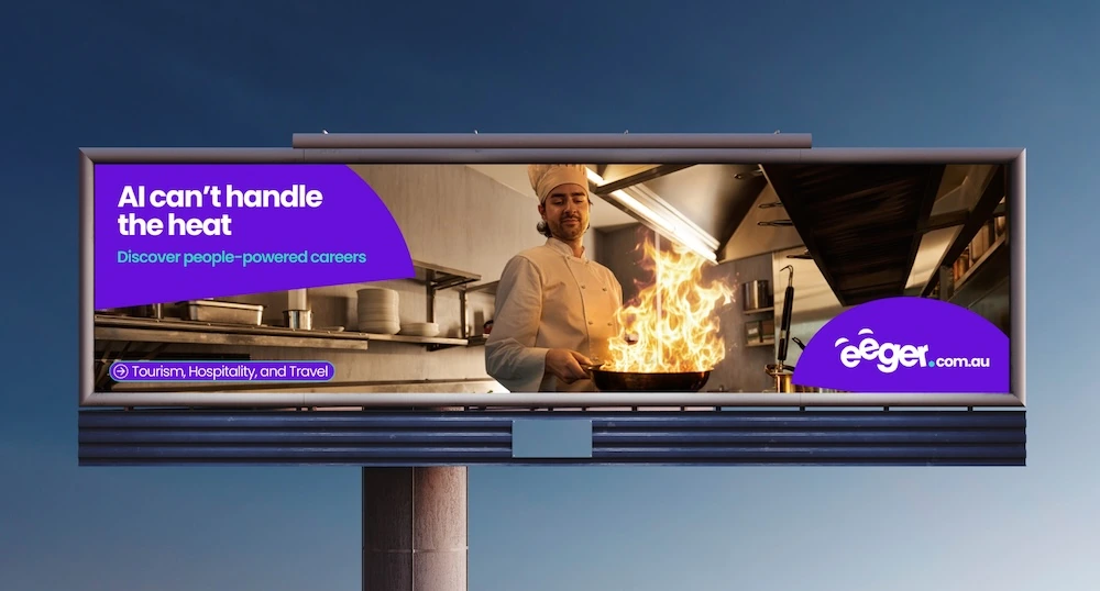 eeger billboard showing a chef cooking over flames with the line AI can’t handle the heat and the People-Powered Careers message.