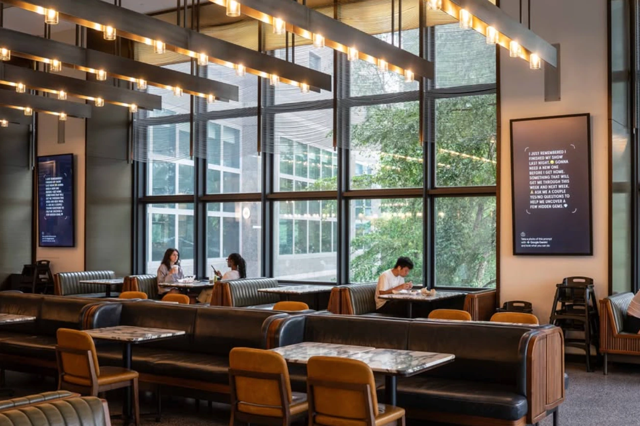Google Gemini prompt-based Digital Out-of-Home screen displayed inside Brookfield Place beside a seating and dining area.