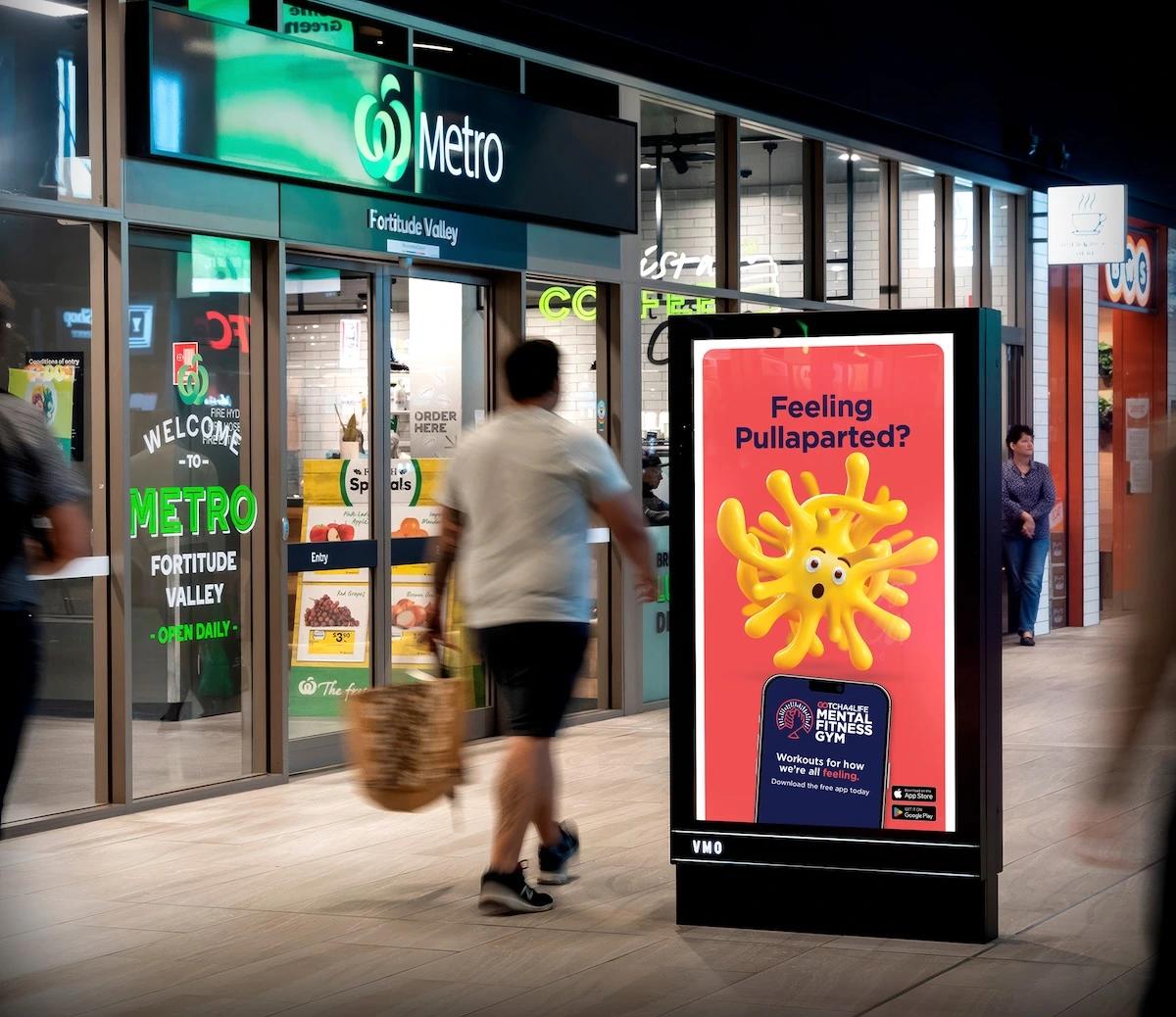 Gotcha4Life digital street furniture ad asking Feeling Pullaparted with a stretched yellow character and Mental Fitness Gym app message.