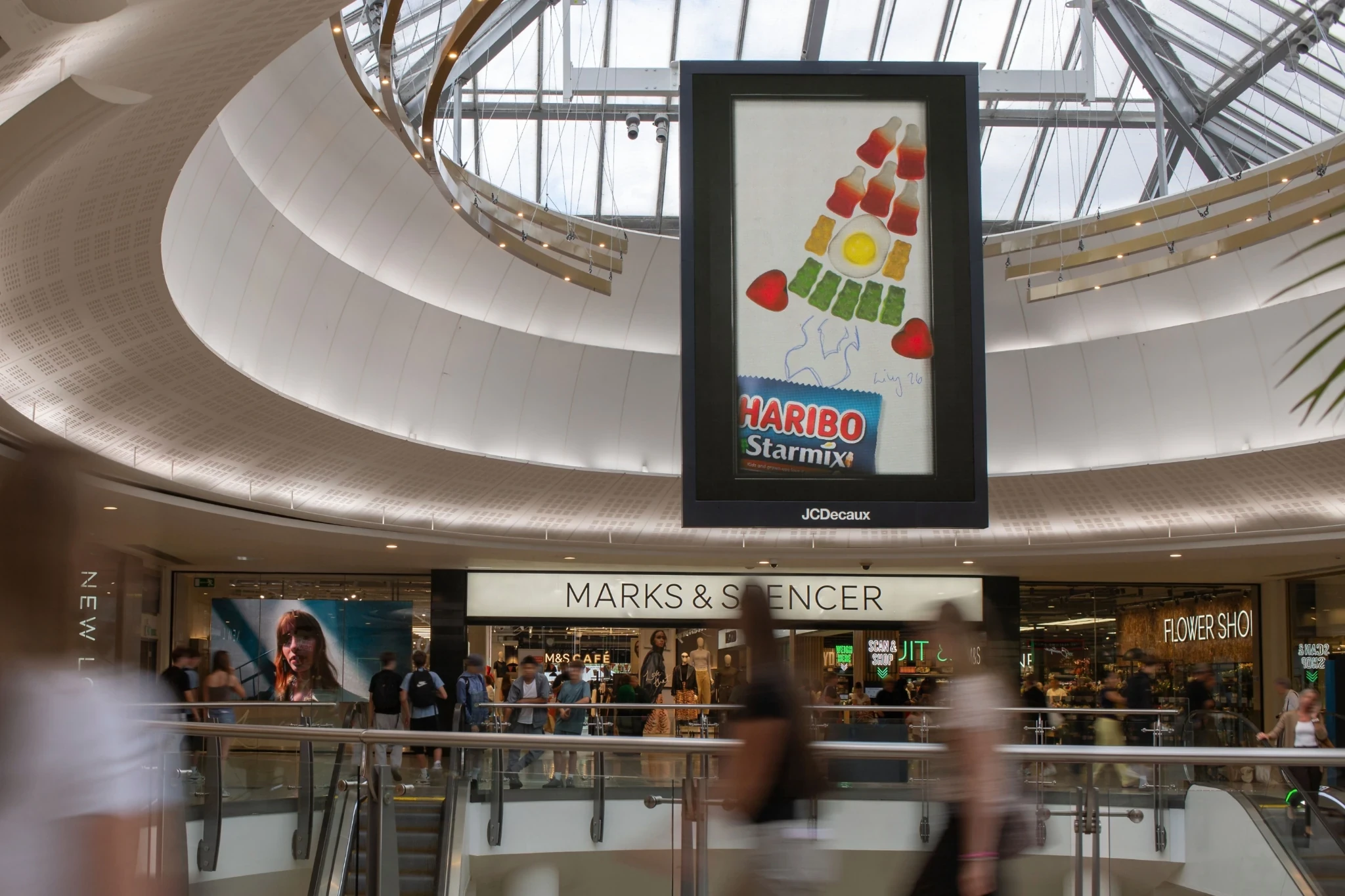 HARIBO Starmix OOH advertisement inside a shopping centre showing colorful gummy pieces arranged as a playful rocket.