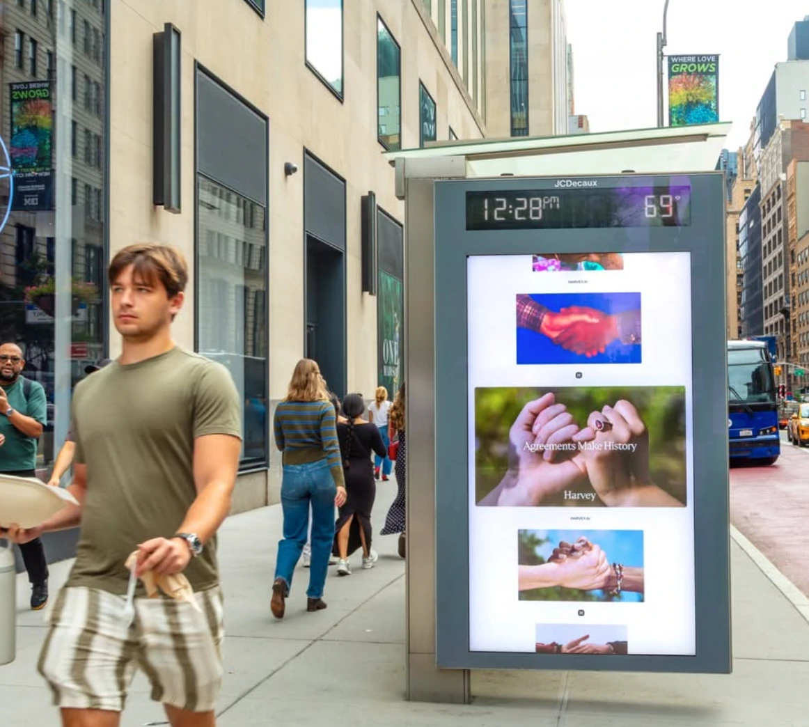 Harvey campaign shown on a city information digital screen with several Agreements Make History images.