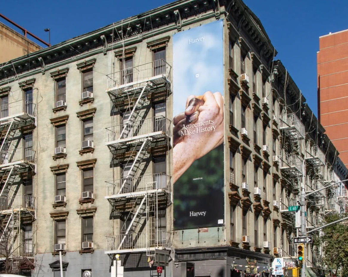 Vertical Harvey Agreements Make History wallscape installed on the side of a city building.