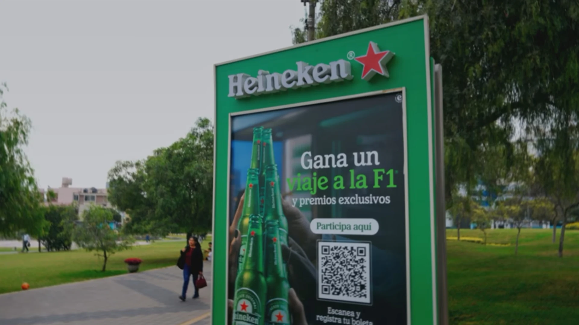 Heineken Formula 1 promotion on a green street advertising panel in Lima inviting people to scan a QR code to enter for an F1 trip and prizes.