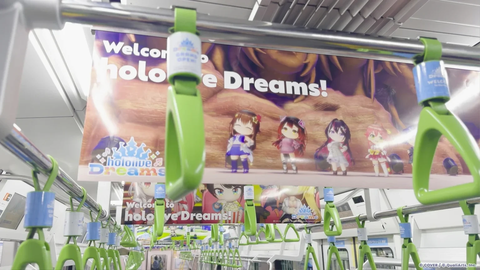 hololive Dreams advertising inside a Yamanote Line train in Tokyo, featuring holodori characters, branded hanging straps and large-format transit posters.