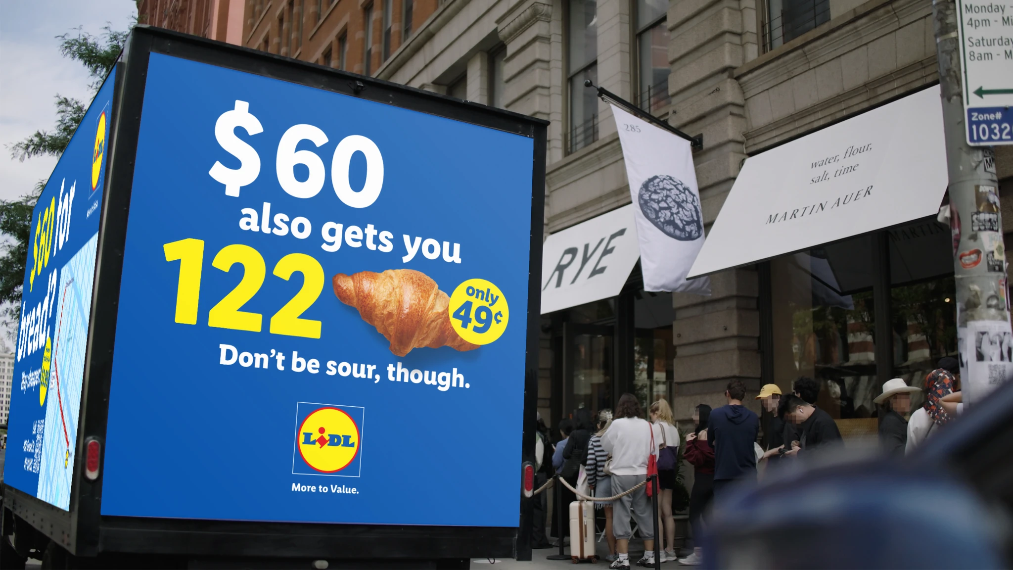 Lidl digital billboard truck in Manhattan showing a message comparing a 60 dollar loaf of bread with Lidl prices outside Rye Bakery.