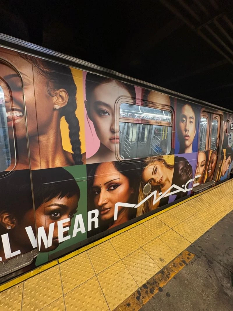 MAC Cosmetics We All Wear MAC campaign covering a New York City subway train with a collage of portrait photography and colorful panels.