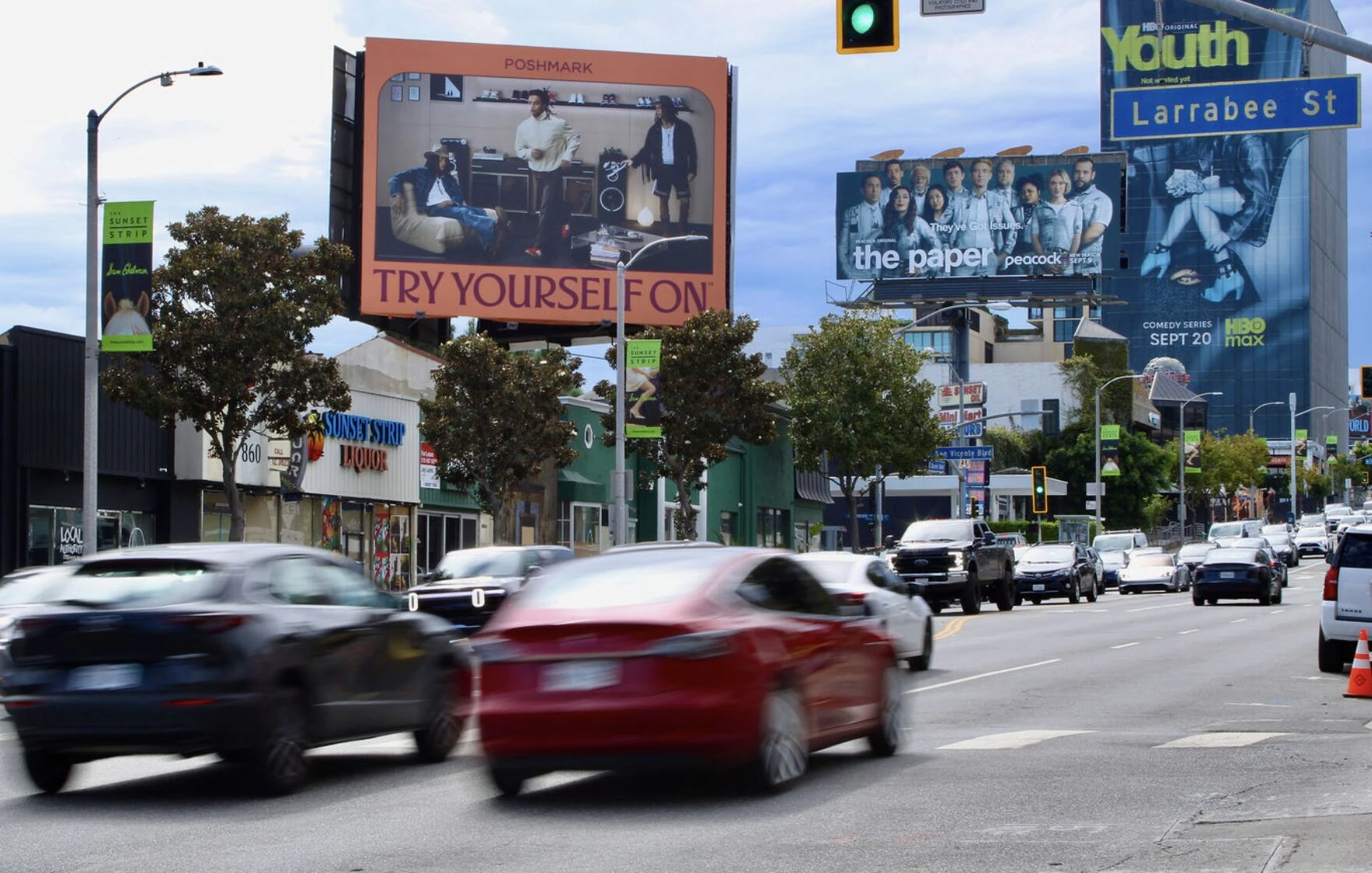 Large Poshmark Try Yourself On billboard displayed above a busy Los Angeles street with pink creative and fashion imagery.
