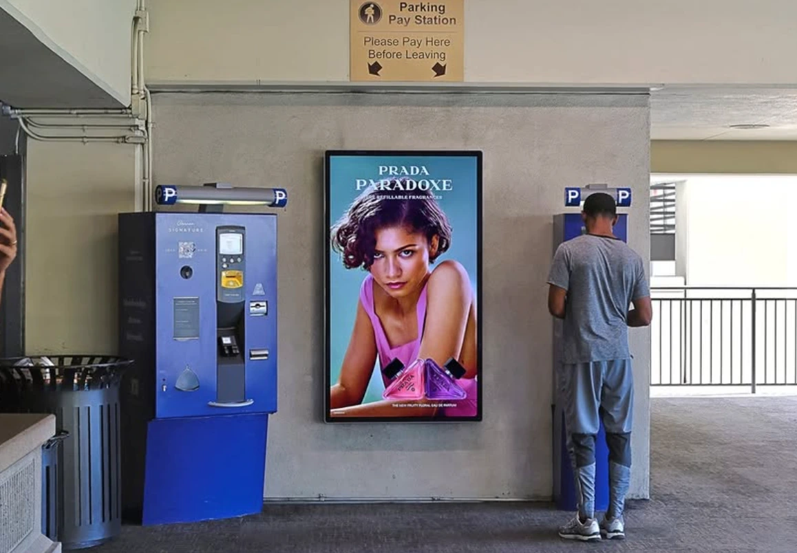 Prada Paradoxe digital advertising displayed beside parking pay stations at The Grove in Los Angeles.