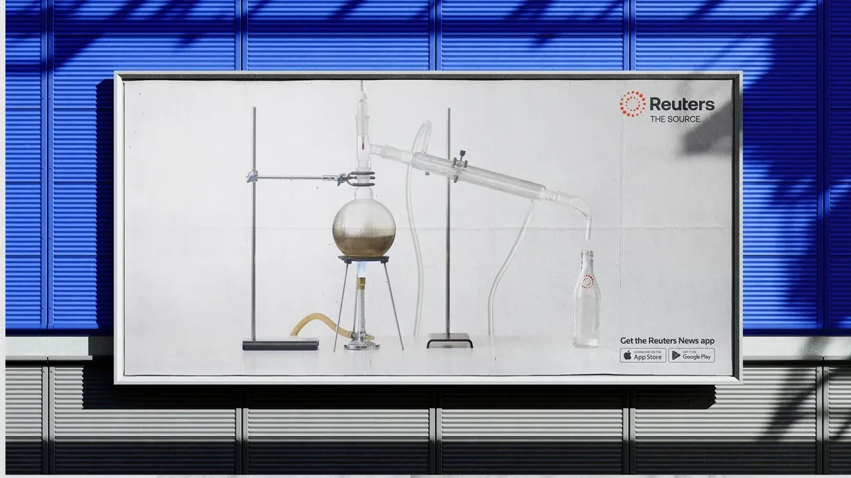 Reuters Pure News, Straight from the Source billboard featuring a laboratory distillation setup as a metaphor for clear, unbiased news.