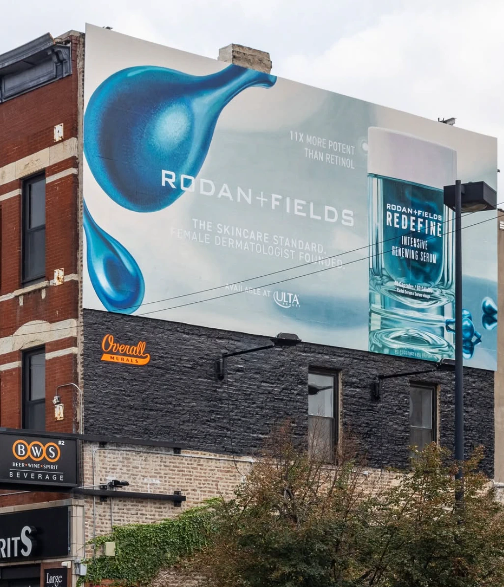 Large-format Rodan + Fields REDEFINE Intensive Renewing Serum wallscape with oversized blue serum imagery and product packaging.