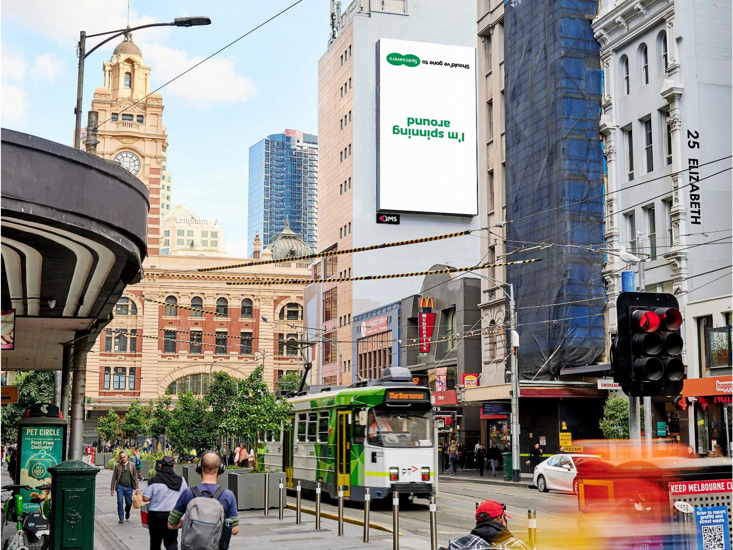 Large-format Specsavers billboard in Melbourne CBD showing the upside-down phrase I’m spinning around as part of a campaign linked to Kylie Minogue and the AFL Grand Final.