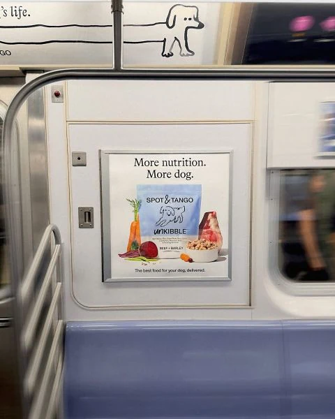 Spot and Tango UnKibble poster inside a New York subway car with the message More nutrition. More dog. and food ingredient imagery.