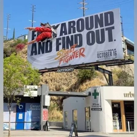 Street Fighter movie billboard with a fighter appearing to crash through the billboard surface above a Los Angeles street.