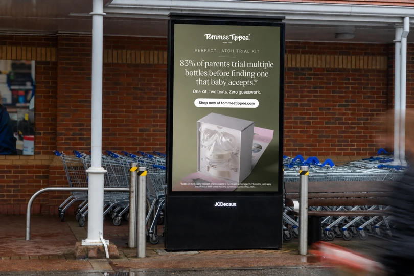 Tommee Tippee Perfect Latch Trial Kit OOH advertisement near shopping carts in the UK explaining that many parents try multiple bottles before finding one their baby accepts.