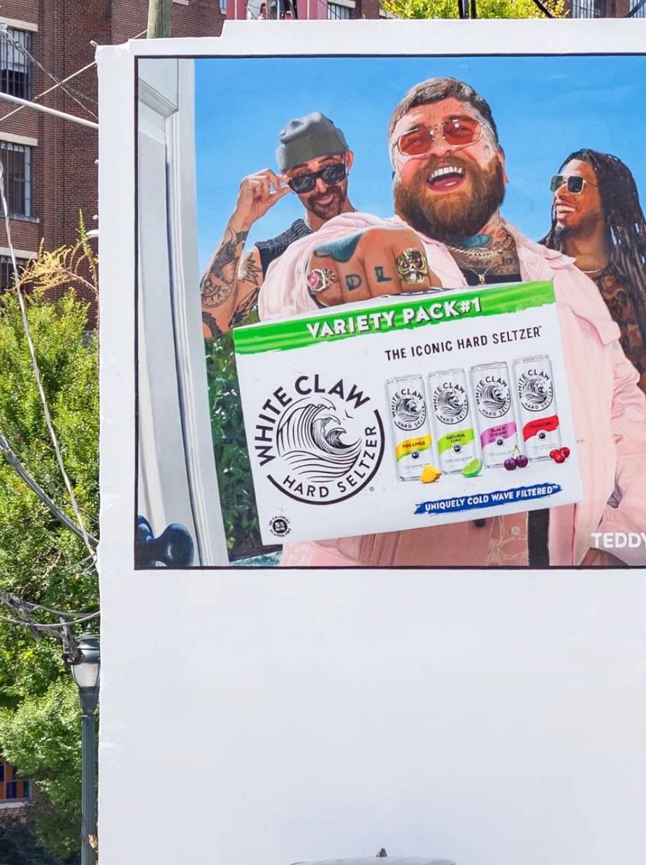 White Claw OOH creative featuring Teddy Swims holding a White Claw Variety Pack with multiple hard seltzer flavors.