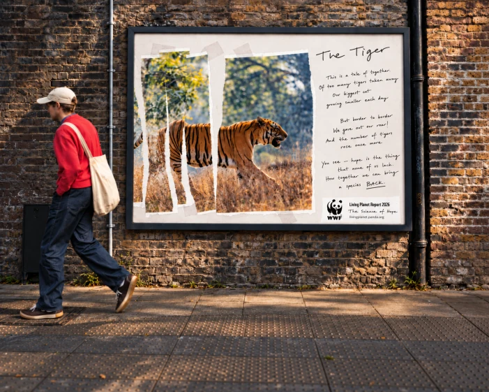 WWF Science of Hope tiger conservation poster installed on a brick wall, showing the Living Planet Report 2026 creative in a street-level OOH advertising placement.